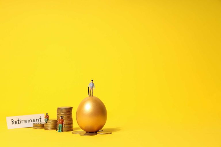 Miniature figures stand on a golden egg surrounded by stacks of coins, with a sign reading "Retirement.
