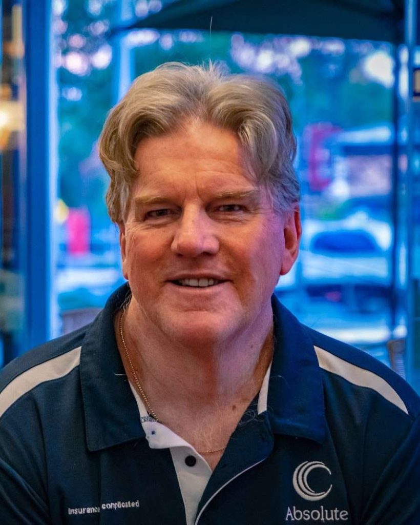 Greg Maguire, Principal of Absolute Insurance, smiling in a Perth cafe