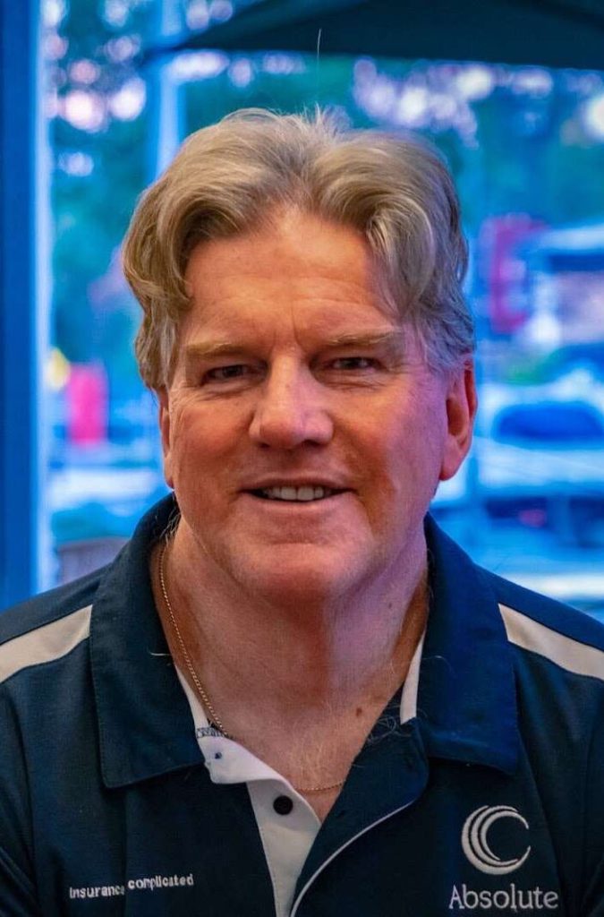Greg Maguire, Principal of Absolute Insurance, smiling in a Perth cafe